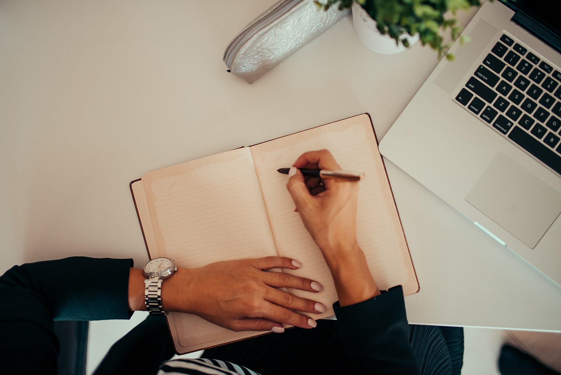 Notizbuch und Laptop am Schreibtisch – Fixkosten-Checkliste zum Abhaken